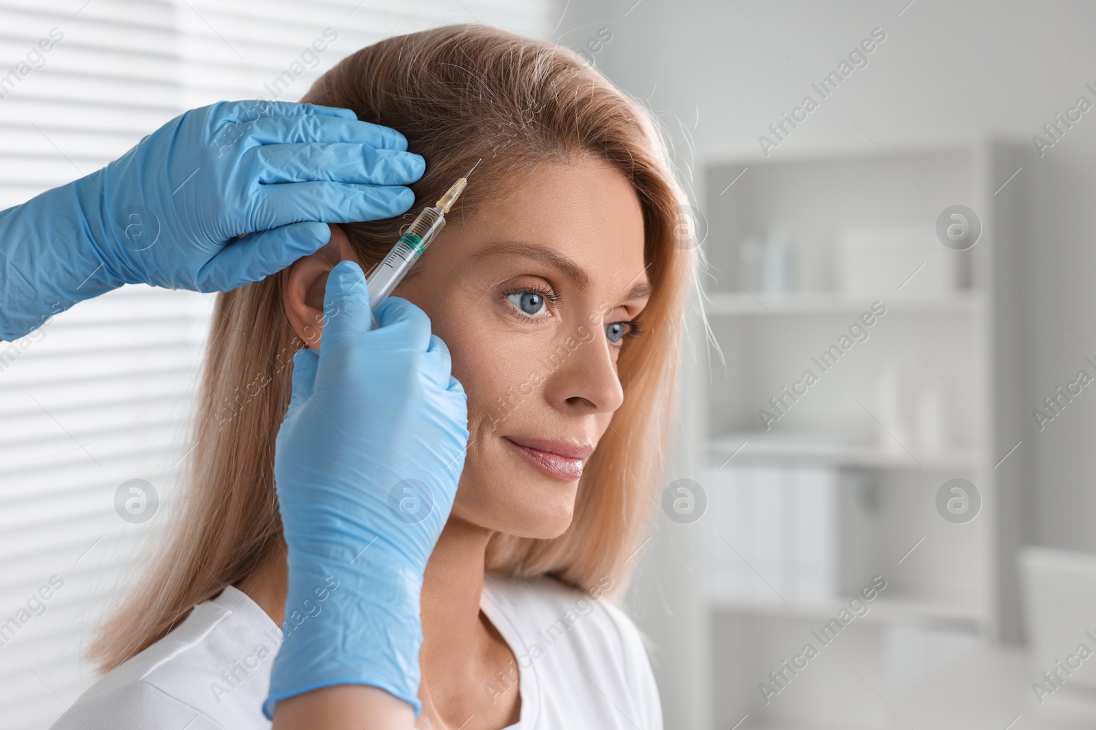 Photo of Trichologist giving injection to patient in clinic, closeup. Space for text