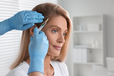 Trichologist giving injection to patient in clinic, closeup. Space for text