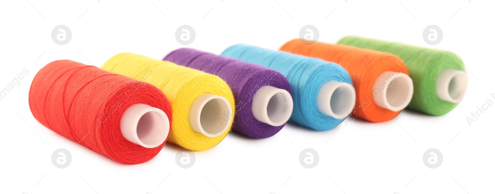 Photo of Set of colorful sewing threads on white background