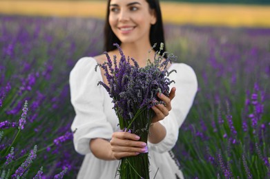 Beautiful young woman with bouquet in lavender field