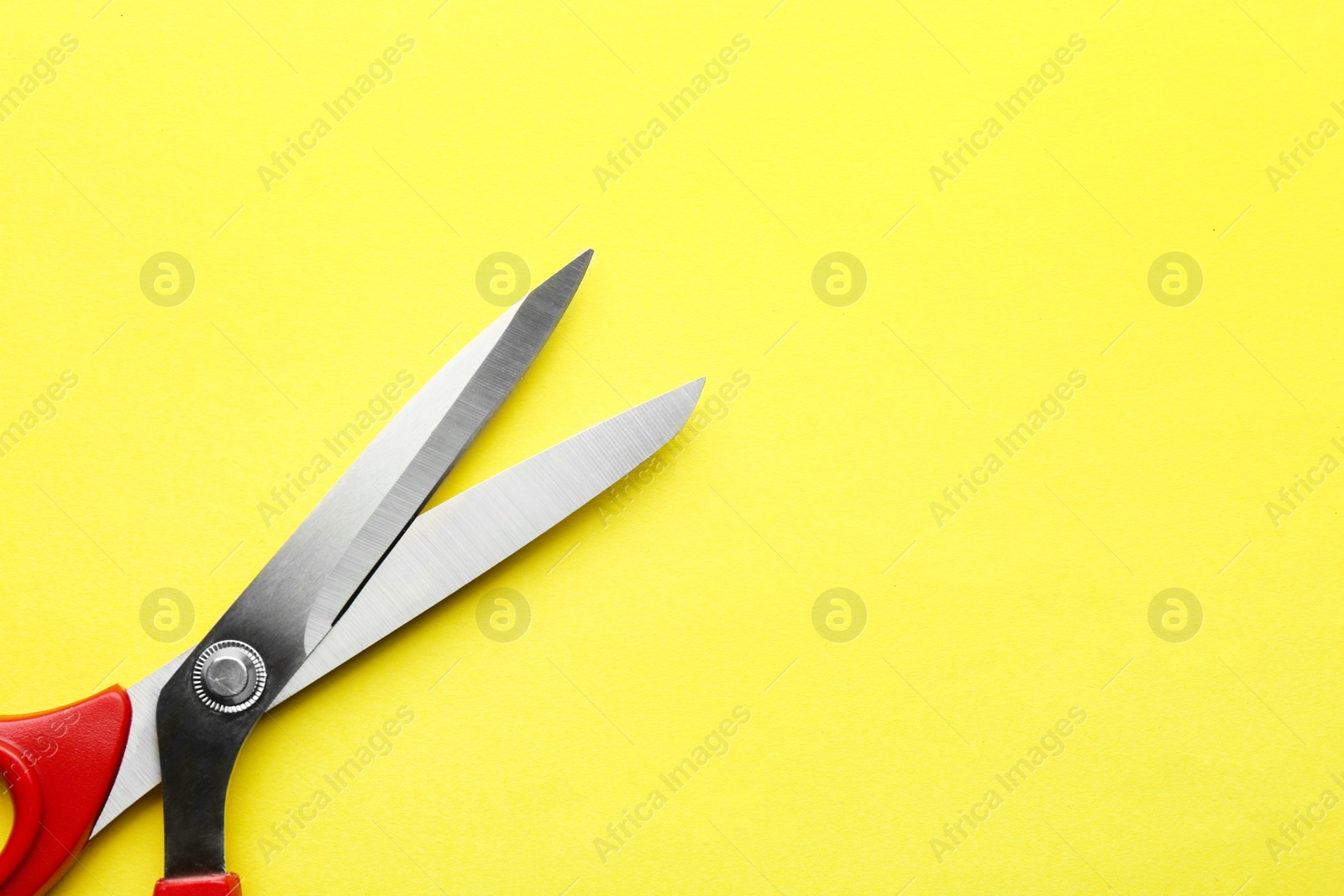 Photo of Pair of sharp scissors on color background, top view. Space for text