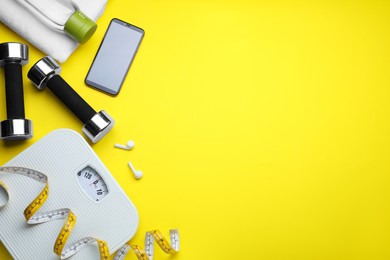 Flat lay composition with scales and measuring tape on yellow background, space for text