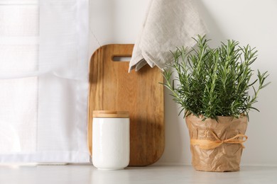Photo of Aromatic green rosemary in pot on white table