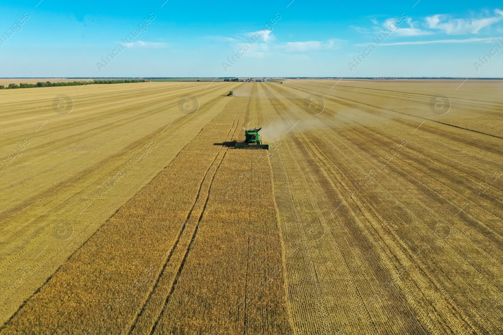 Photo of Modern combine harvester working in field on sunny day. Agriculture industry