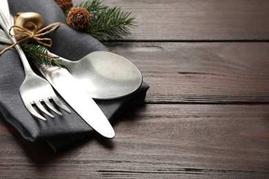 Photo of Cutlery set and festive decor on wooden table, closeup with space for text. Christmas celebration