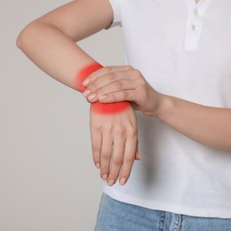 Woman suffering from rheumatism on light background, closeup