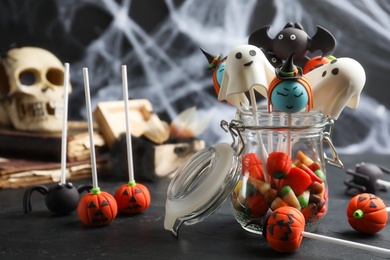 Different Halloween themed cake pops on black table