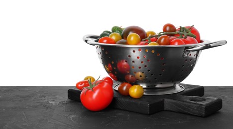 Photo of Metal colander with fresh tomatoes on black textured table against white background, space for text