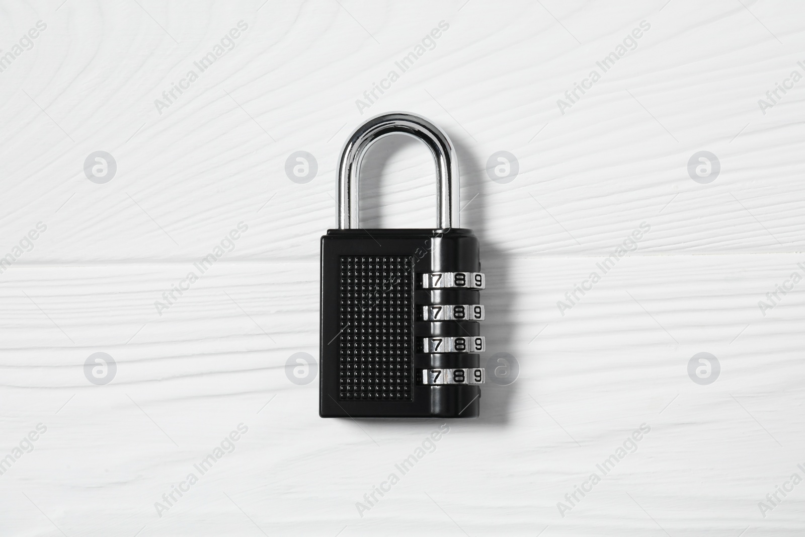 Photo of One steel combination padlock on white wooden table, top view