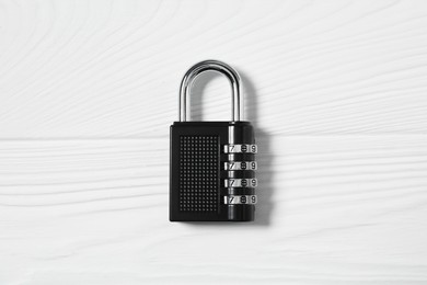 One steel combination padlock on white wooden table, top view