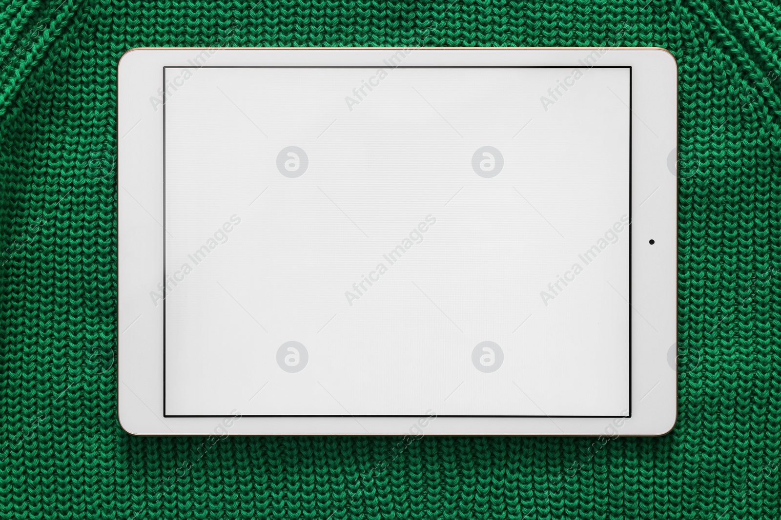 Photo of Modern tablet on green fabric, top view. Space for text