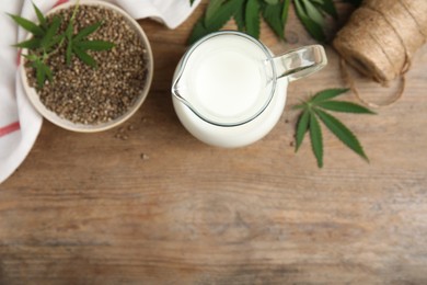 Flat lay composition with fresh hemp milk on wooden table. Space for text