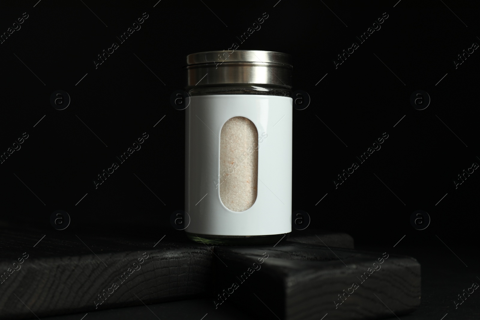 Photo of Salt shaker on table against black background