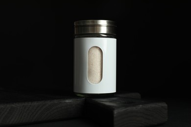 Salt shaker on table against black background