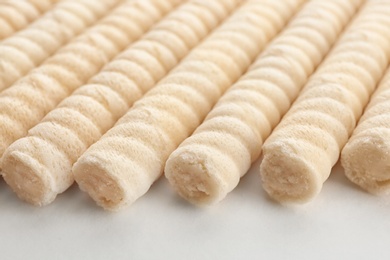 Delicious wafer rolls on white background, closeup. Sweet food