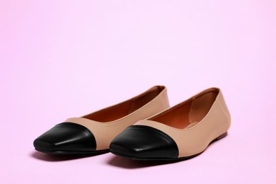Photo of Pair of new stylish square toe ballet flats on pale pink background