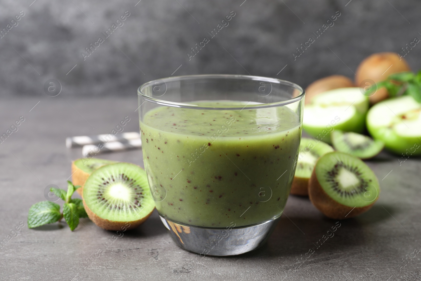 Photo of Delicious kiwi smoothie and fresh fruits on grey table