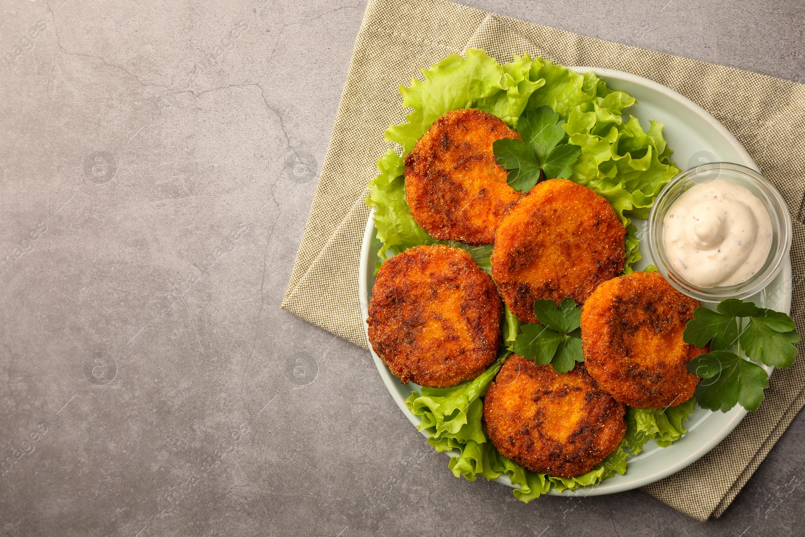 Photo of Tasty vegan cutlets with sauce on light grey table, top view. Space for text