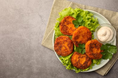 Tasty vegan cutlets with sauce on light grey table, top view. Space for text