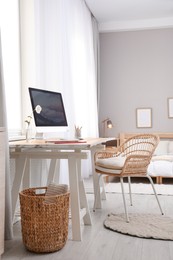 Comfortable workplace with modern computer near window in bedroom. Interior design