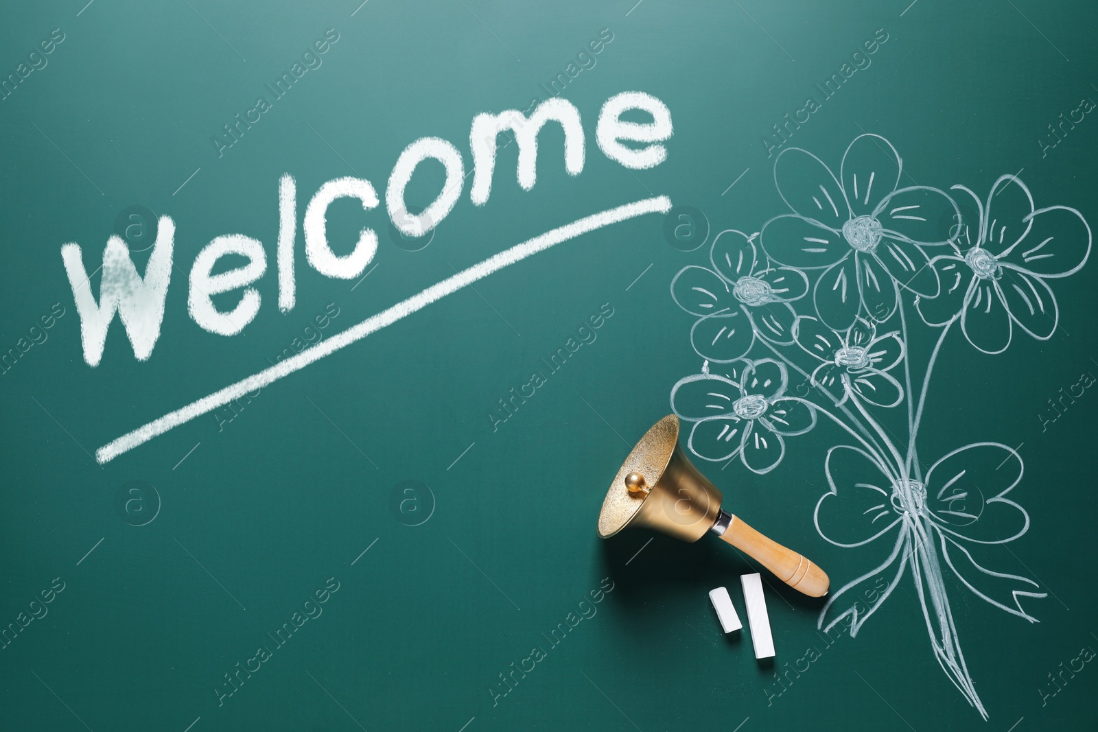 Image of Welcome card. Golden bell, chalk, word and drawn flowers on green board, flat lay