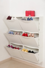 Photo of Shoe cabinet with footwear in room. Storage ideas