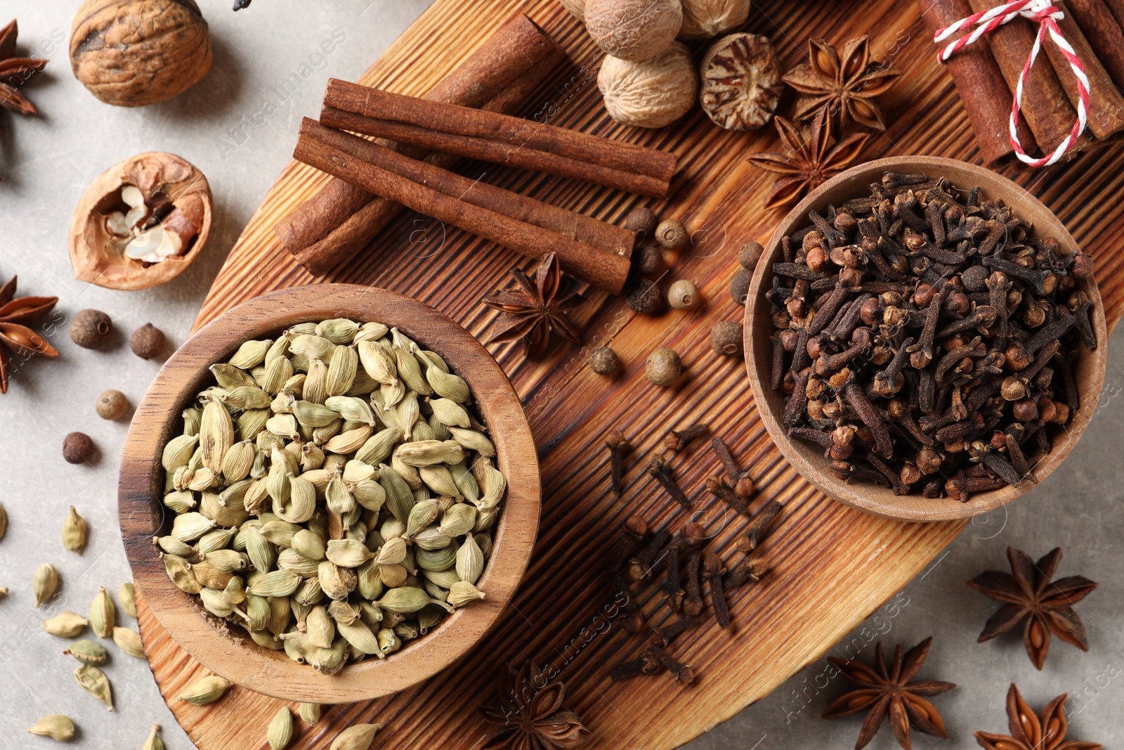 Photo of Different spices and nuts on light gray table, flat lay