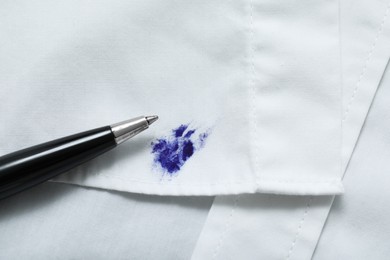 Photo of Pen and stain of blue ink on white shirt, closeup. Space for text