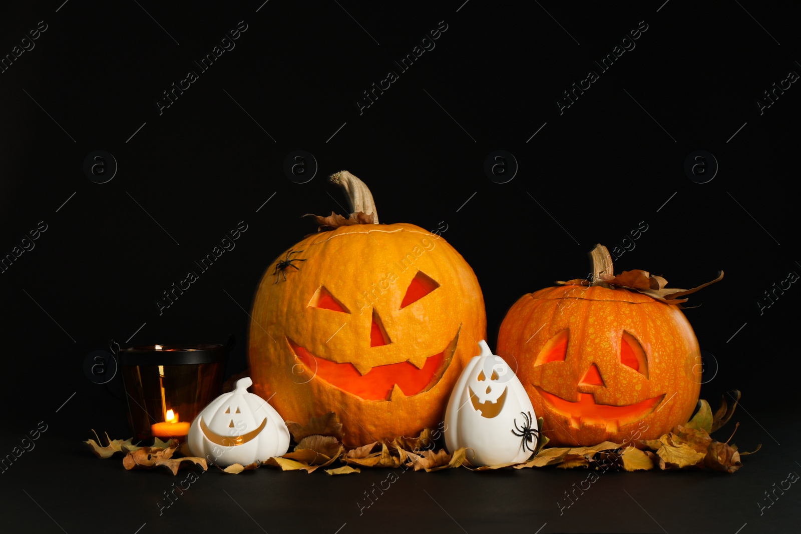Photo of Composition with pumpkin heads on black background. Jack lantern - traditional Halloween decor