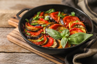 Photo of Delicious ratatouille in frying pan on wooden table, closeup