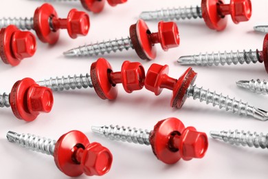 Photo of Red self-tapping screws on white background, closeup