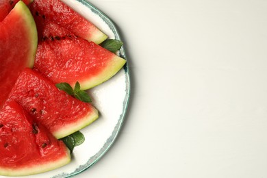 Photo of Cut juicy watermelon served on white wooden table, top view. Space for text