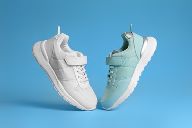Photo of Two stylish sneakers on light blue background