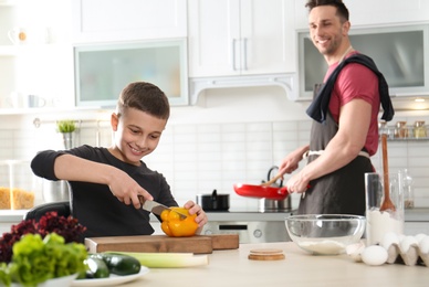 Photo of Dad and son cooking together in kitchen