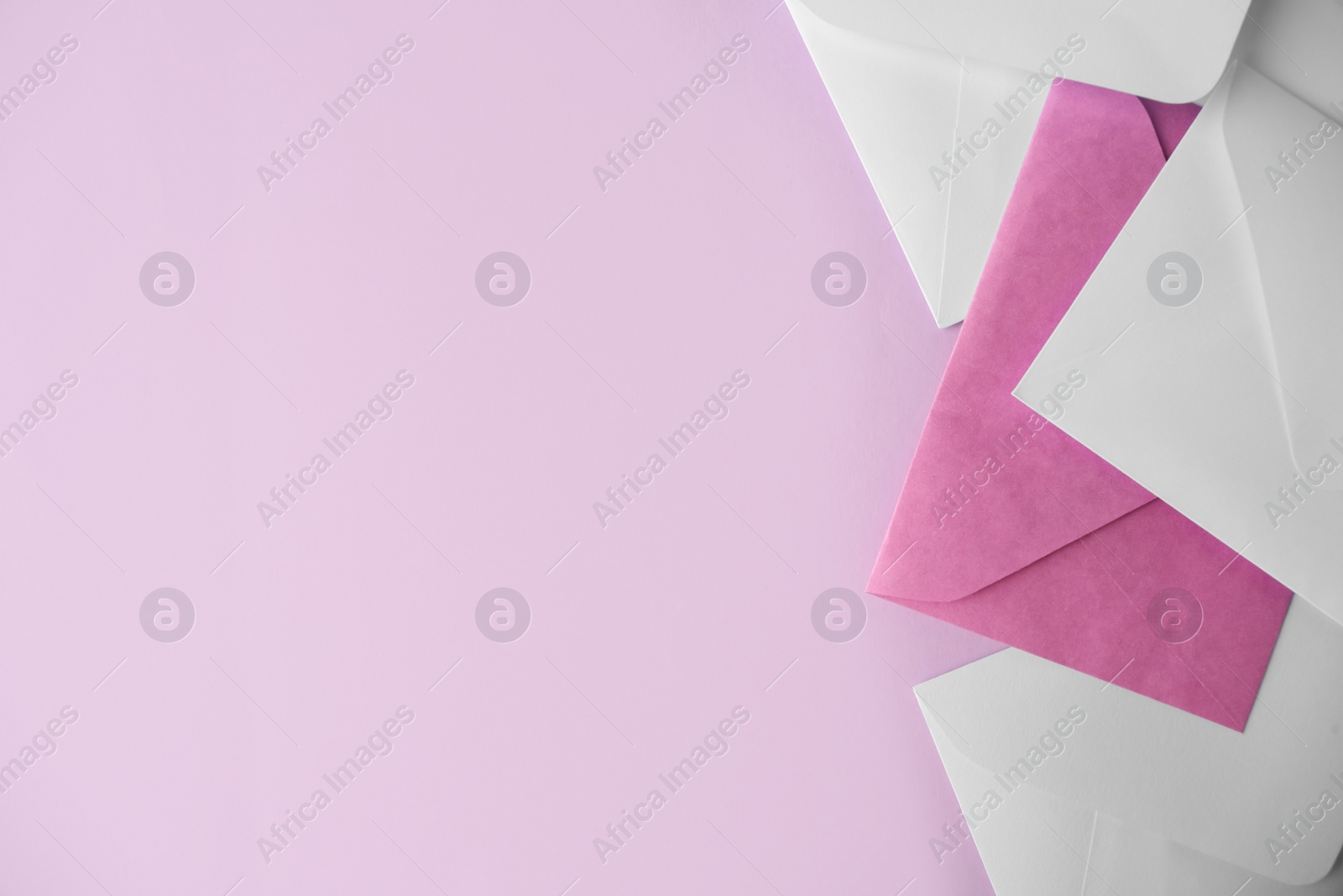 Photo of Colorful paper envelopes on pink background, flat lay. Space for text