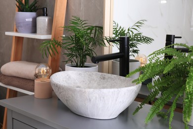 Photo of Stylish vessel sink and beautiful green houseplants in bathroom