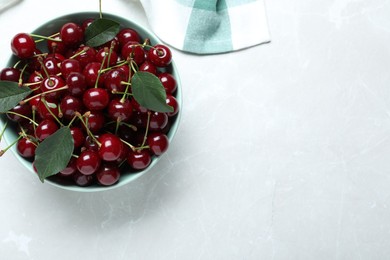 Photo of Sweet juicy cherries on light marble table, top view. Space for text
