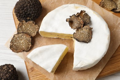 Photo of Soft cheese and fresh truffles on table, above view