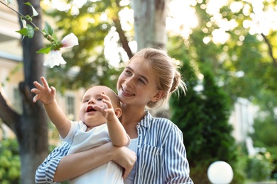 Teen nanny with cute baby in park on sunny day