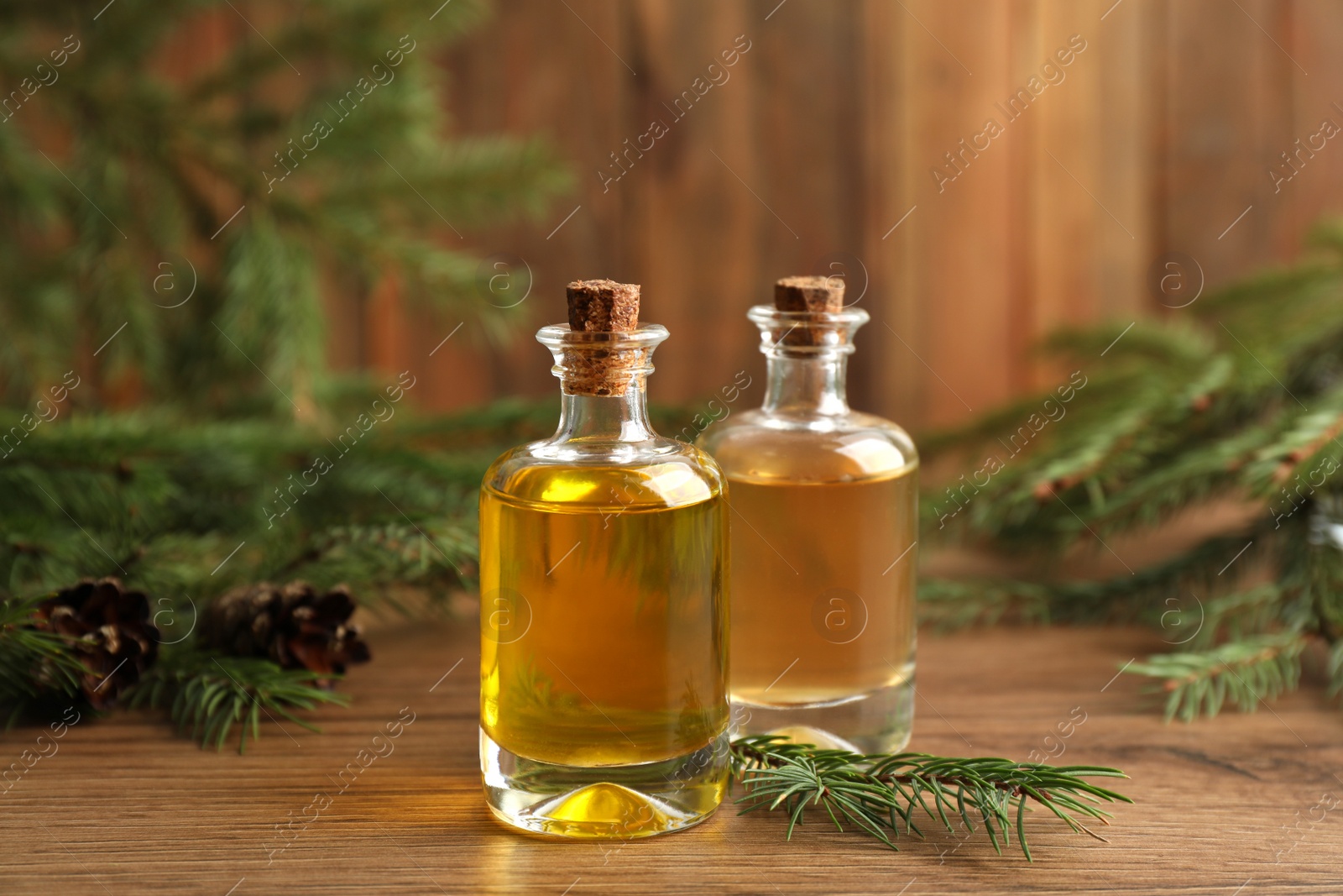 Photo of Bottles with pine essential oil on wooden table