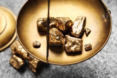 Photo of Vintage scales with gold nuggets on grey table, above view