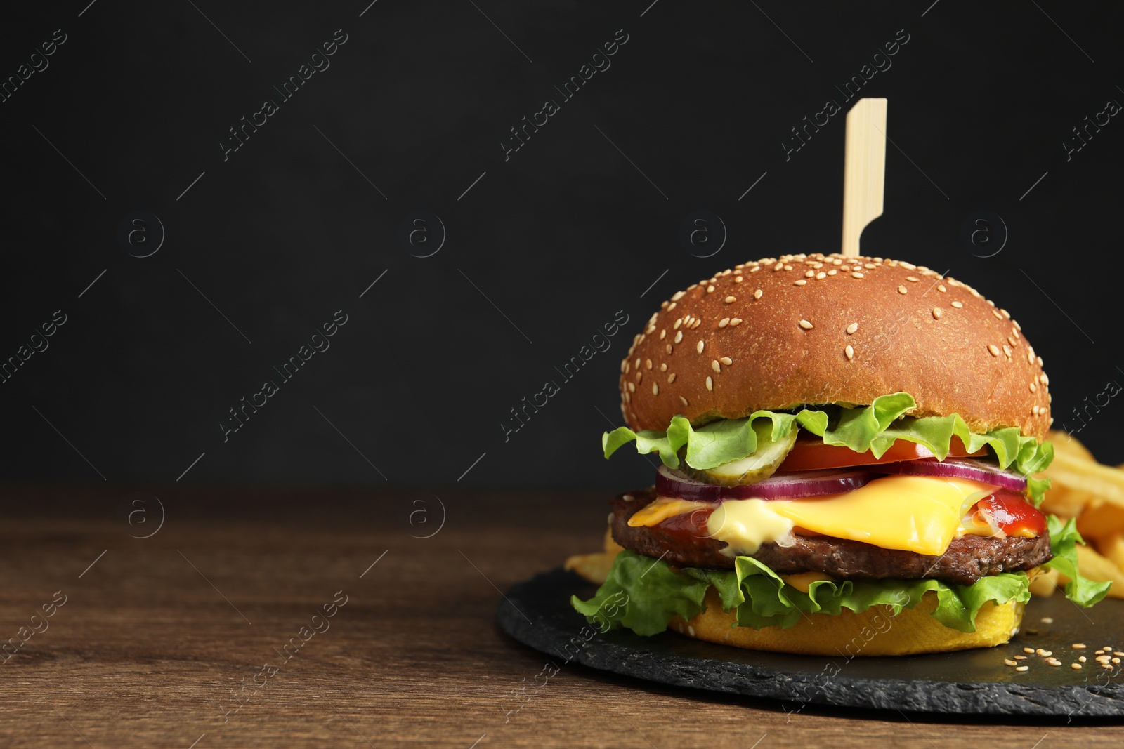 Photo of Delicious burger with beef patty on wooden table. Space for text