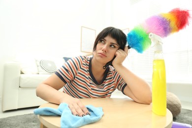 Photo of Lazy woman procrastinating while cleaning at home