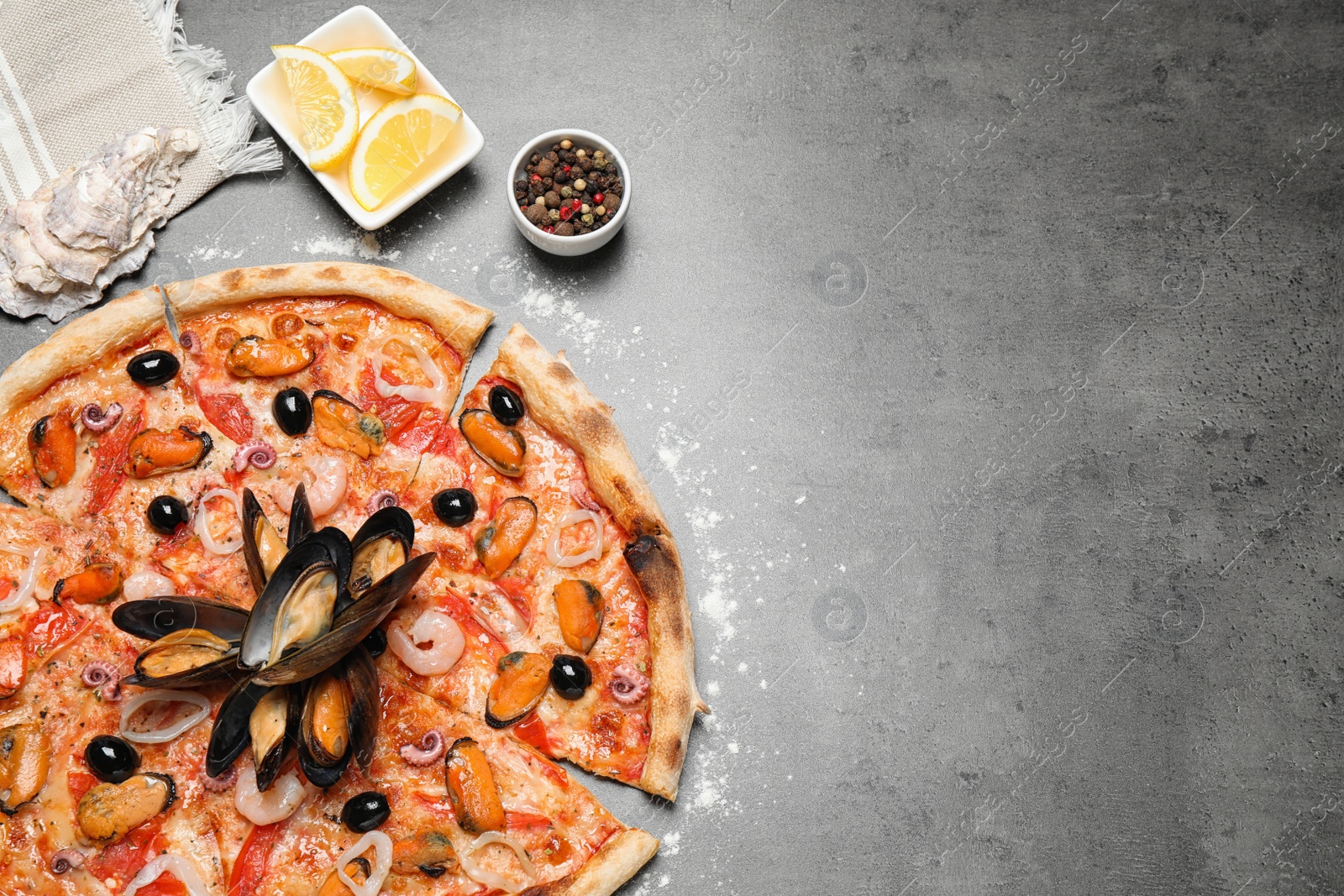 Photo of Tasty pizza with seafood and ingredients on grey table, flat lay. Space for text