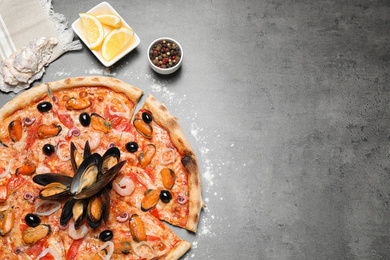 Photo of Tasty pizza with seafood and ingredients on grey table, flat lay. Space for text