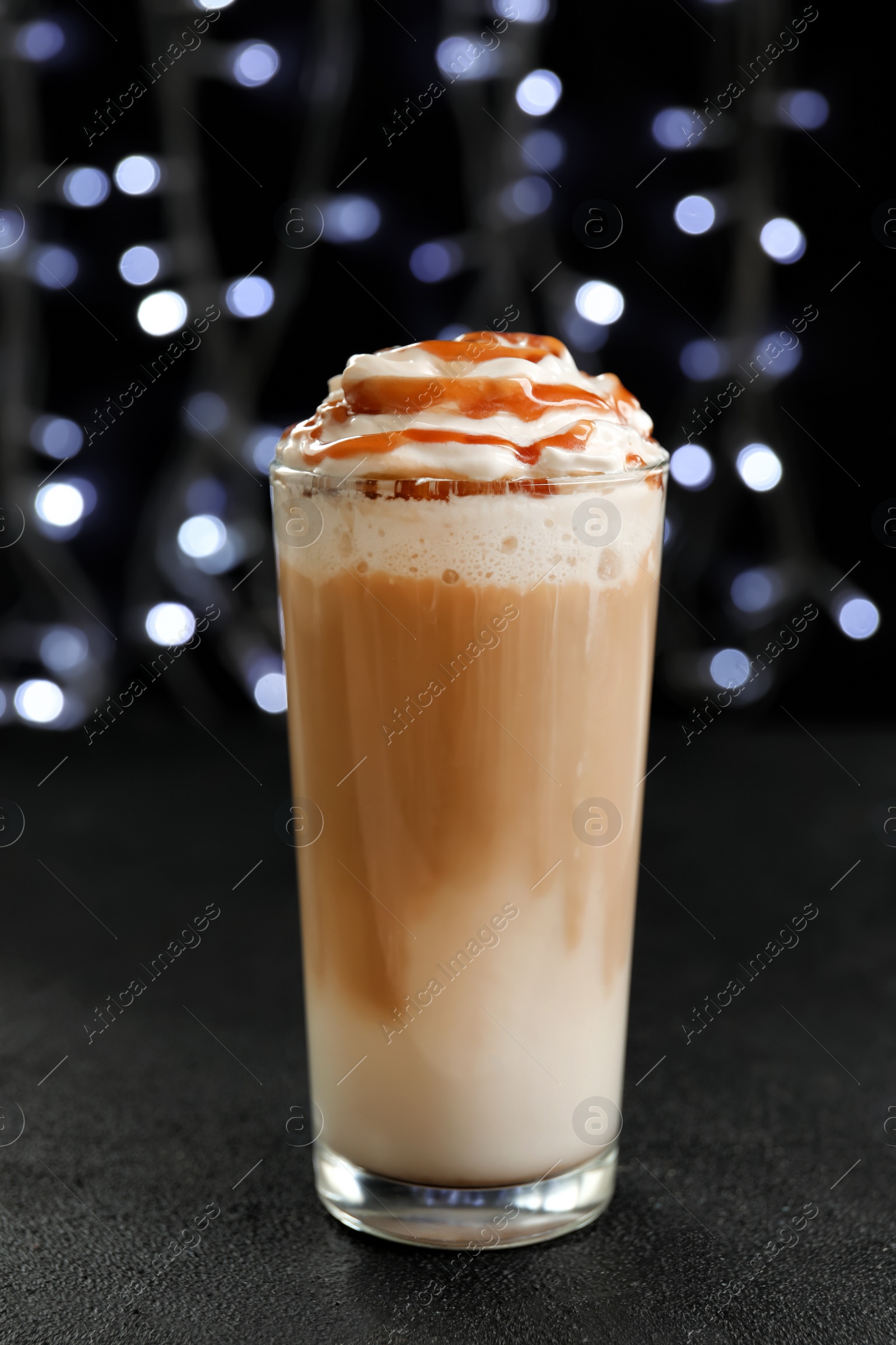 Photo of Glass with delicious caramel frappe on table