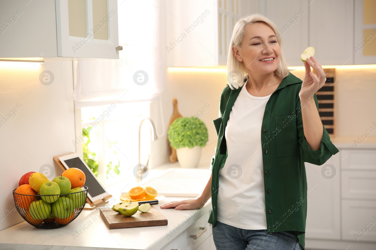 Photo of Woman with tablet cooking at counter in kitchen