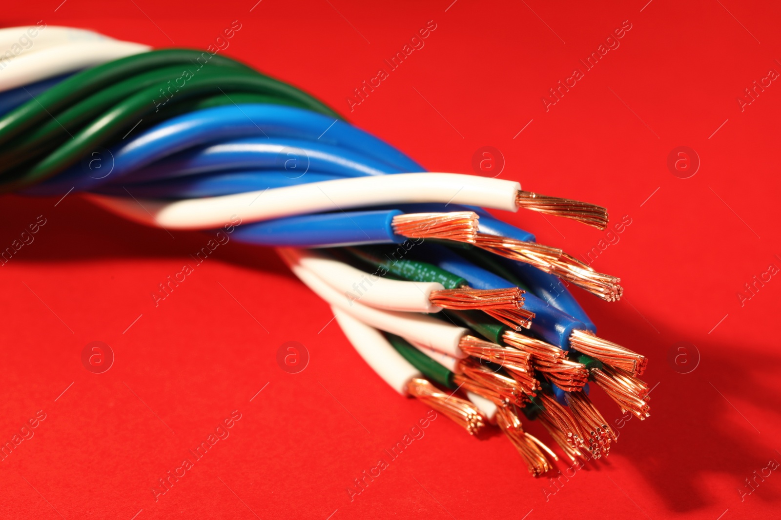 Photo of Electrical wires on red background, closeup view