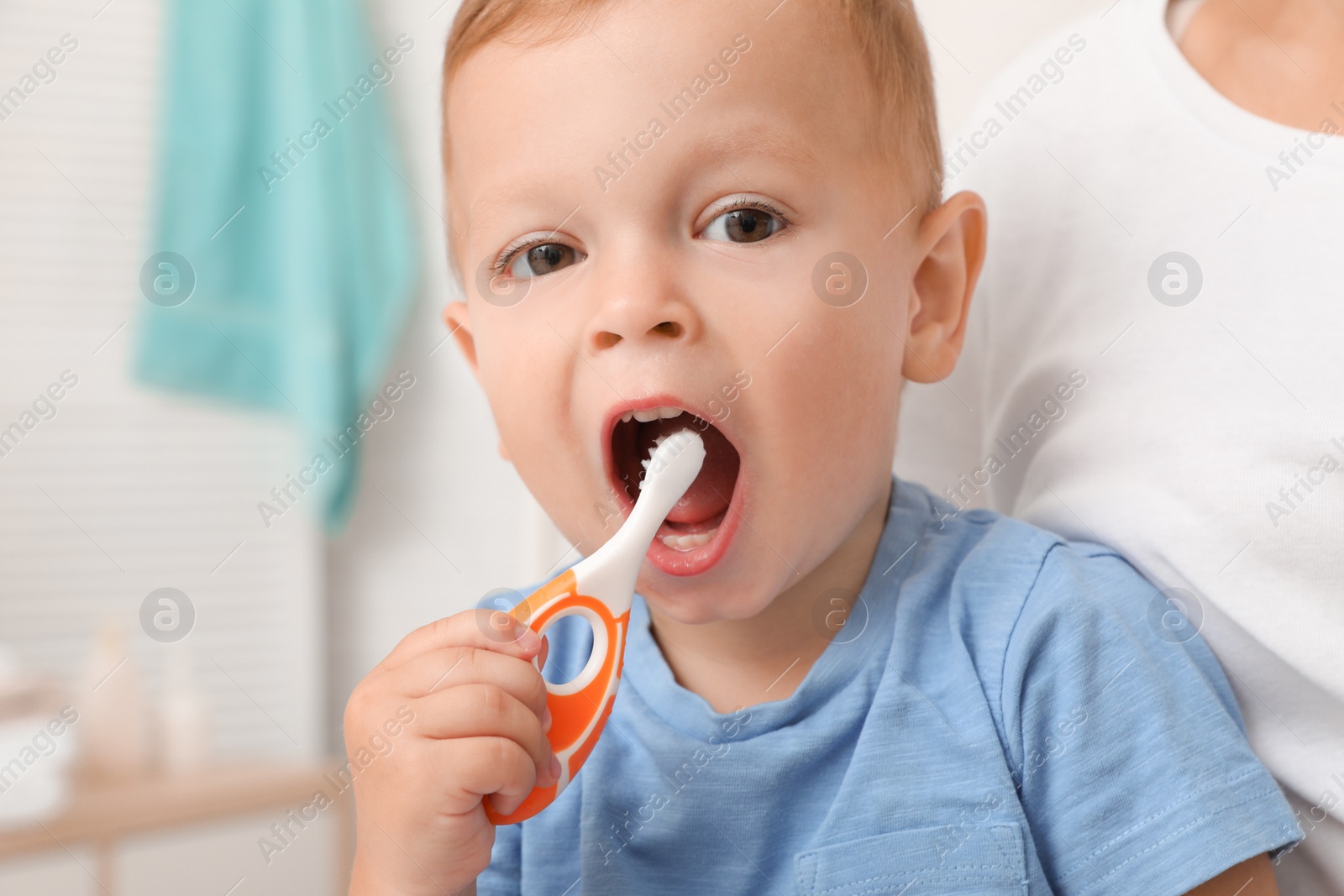 Photo of Woman and her son with toothbrush on blurred background