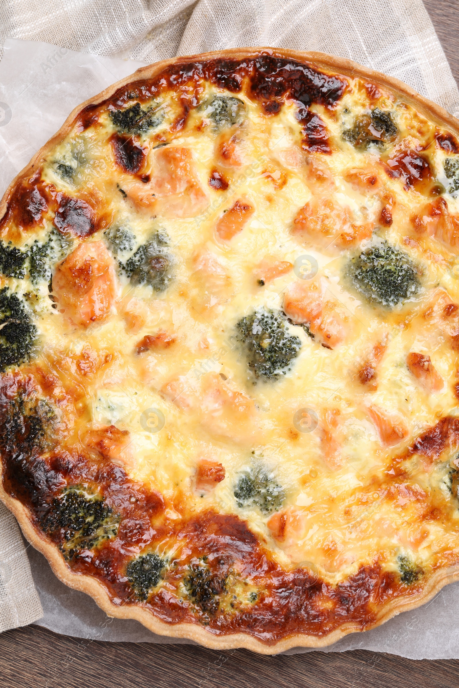 Photo of Delicious homemade quiche with salmon and broccoli on table, top view